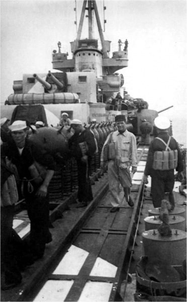 Файл:Duca Мины ЕМС на борту «Дука д’Аоста» 2 июня 1941 г. Справа глубинные бомбы типа 50-1936. Окраска палубы красно-белыми полосами.jpg